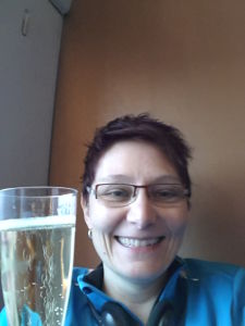 The photo shows me with a glass of sparkling wine.